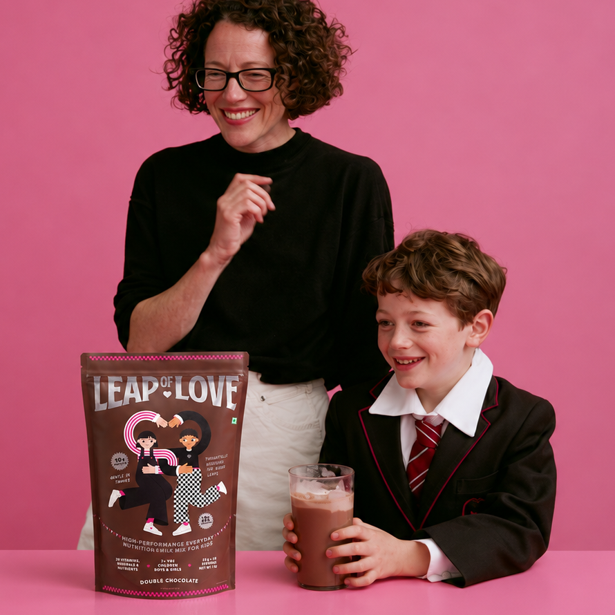 Mother and son in school uniform with the Leap of Love Double Chocolate 1 kg bag and a glass of chocolate milk
